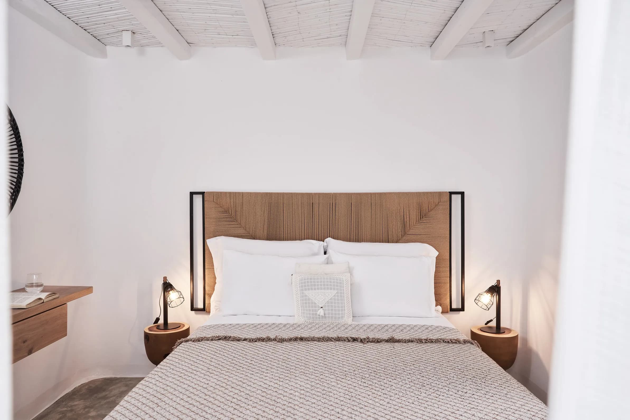 Bedroom with a double bed, woven headboard and bedside lamps